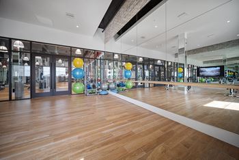 a large gym with a wooden floor and large mirrors on the wall at Altis Grand Central, Florida